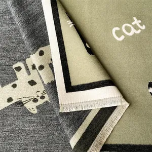 Detail van dubbelzijdige gebreide sjaal met kattenpatroon en mintgroene Cat tekst