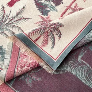 Close-up of double-sided knit scarf showing tropical palm pattern and soft tassel texture