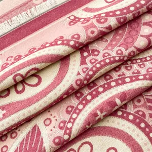 Gros plan sur un châle en cachemire rose avec motifs jacquard paisley et bords à franges