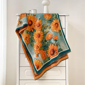 Detail showing sunflower pattern and orange tassels on a thick woven shawl scarf
