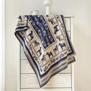 Détail d'une écharpe nordique à motif de cheval de Dala bleu et beige et fleurs vintage