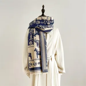 Détail d'une écharpe vintage bleu marine et grise avec motifs de chevaux et franges