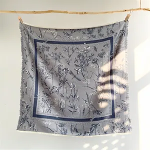 Détail de l'imprimé floral et franges sur le foulard carré bleu de style vintage