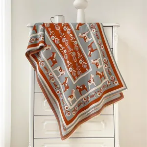 Détail des motifs de chevaux nordiques et fleurs sur l'écharpe épaisse et chaude pour femme