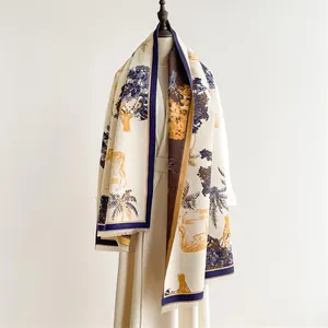 Detail of soft cashmere-feel scarf featuring navy giraffe prints and fine fringe edges