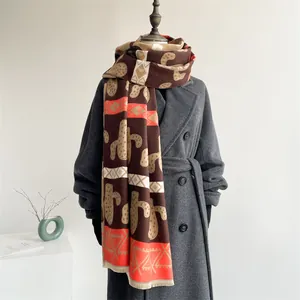 Detail of Nordic style scarf with cactus patterns and fringes on a grey wool coat