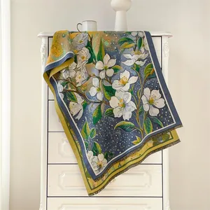 Detail of oil painting style floral scarf with tassels draped on a white drawer cabinet