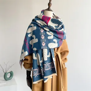 Detail of blue Nordic shawl with cactus print and fringe tassels on a coat