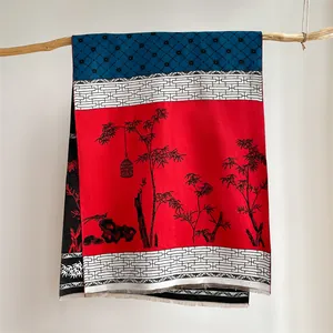 Close-up of vintage ethnic red shawl with bamboo patterns and fringed hem detail