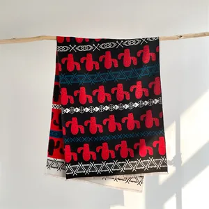 Detail of Nordic style cashmere-like scarf showing cactus print and tassel fringe texture