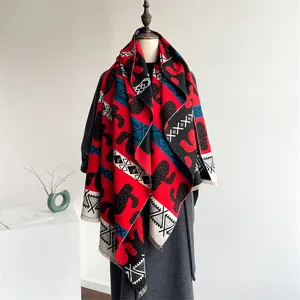 Detail of red and black bohemian shawl with cactus patterns and fringe finish