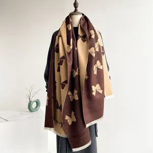Detail of winter scarf featuring double-sided jacquard bow pattern and fringe edges