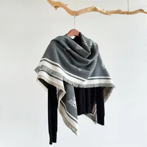Close-up of grey shawl featuring white bee prints and elegant fringe tassel edges