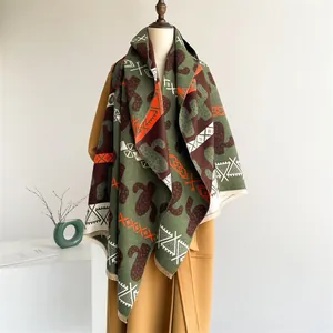 Close-up of cashmere-like scarf with green cactus pattern and ethnic geometric details