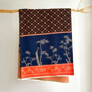 Detail of vintage scarf with bamboo patterns hanging on a dry branch for display