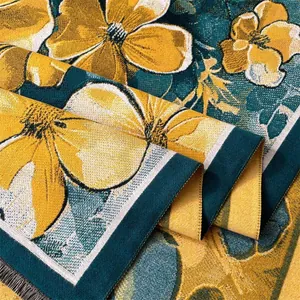Close-up of winter jacquard scarf featuring yellow floral patterns and black fringe