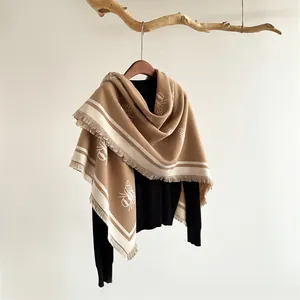 Detail of bee pattern scarf with fringe edges and brown beige color block design