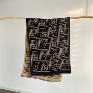 Écharpe réversible noir et camel avec motif géométrique jacquard et bordures à franges
