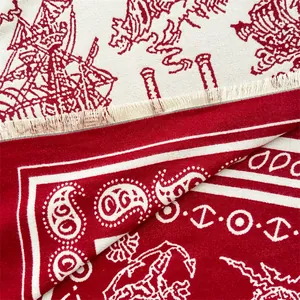 Detail of red and white paisley jacquard fabric showing intricate weave and soft fringes