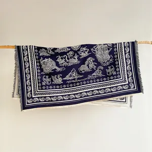 Detailed texture of navy blue paisley shawl with nautical mermaid and sailing ship motifs