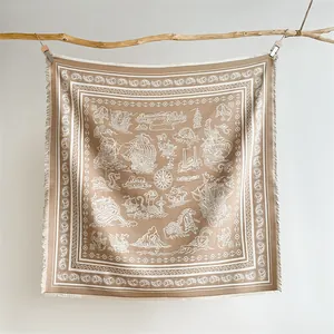 Detail of vintage paisley shawl featuring nautical prints and fringed edges on wood branch