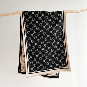 Detailed view of reversible floral scarf with fringes hanging on a wooden branch