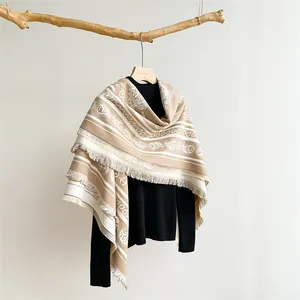 Macro detail of khaki paisley pattern scarf with soft fringe on wooden hanger