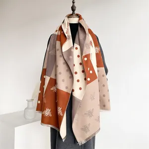 Macro detail of bee illustration and geometric color block on soft cashmere feel scarf