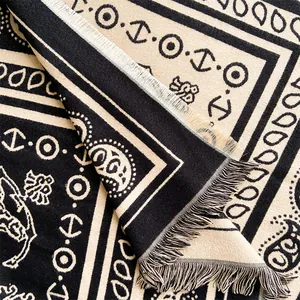 Close-up of paisley jacquard knit shawl with fringe tassels and high-quality texture