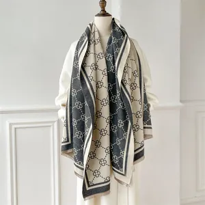 Detailed view of thick winter shawl featuring grey floral jacquard and soft fringe tassels
