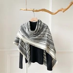 Detail of grey and white paisley print pashmina with soft fringe edges for winter