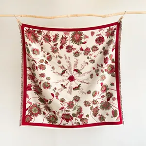 Detail of woven sunflower square scarf with cream base and red fringed edges on hanger
