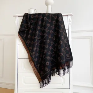 Detail view of double-sided jacquard scarf with tassels and geometric patterns