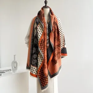 Detail eines weichen Strickschals mit Vintage-Rosenmustern, Punkten und Fransen