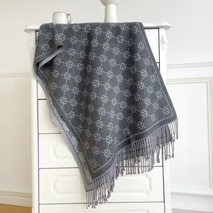 Detailed view of grey cashmere-feel scarf with jacquard floral pattern and soft tassels