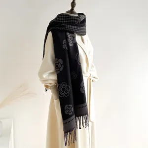 Elegant camellia and houndstooth scarf with tassels on cream coat for autumn