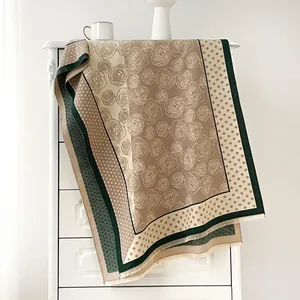 Detail eines Vintage-Seidenschals mit Polka-Dot- und Kamelienmuster und edlen Fransen
