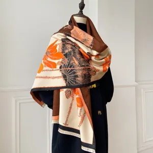 Detail of elegant lotus print shawl with tassels on a model wearing a black coat