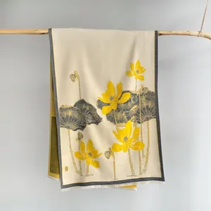 Detail of artistic lotus flower print and delicate frayed edges on a beige scarf