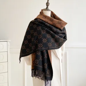 Brown and black double-sided floral scarf with long tassels on a mannequin display