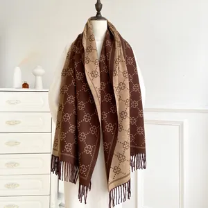 Brown cashmere-feel scarf with geometric floral pattern and long fringe on a mannequin
