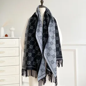 Women's black and grey floral jacquard knit scarf with long tassels on a white mannequin