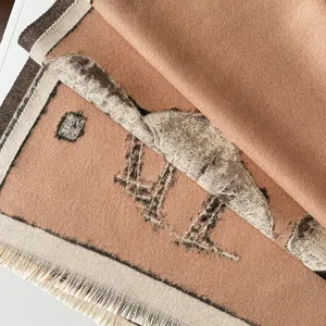 Detailed view of winter jacquard scarf with fringe and warm earthy camel tones
