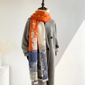 Close-up of fringe tassels on orange and blue floral cashmere-feel scarf shawl