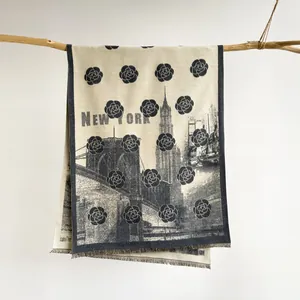 Detail of cashmere scarf featuring New York skyline patterns and soft fringe edges