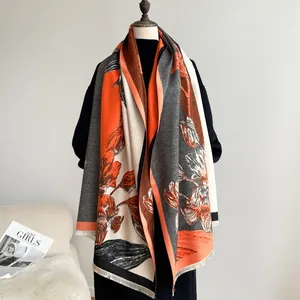 Detail of vintage floral cashmere-like shawl with orange flowers and fringe trim