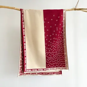 Detail of burgundy and cream cashmere shawl featuring rose patterns and geometric textures