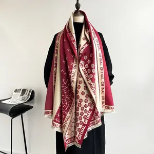 Detailed close-up of a two-tone red and beige camellia cashmere shawl with fringe trim