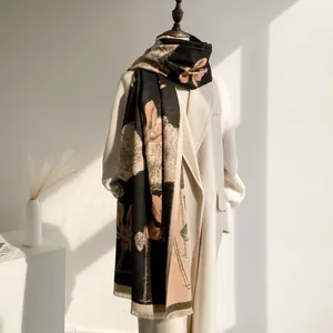 Detail of elegant black and beige floral cashmere-feel scarf with delicate frayed edges