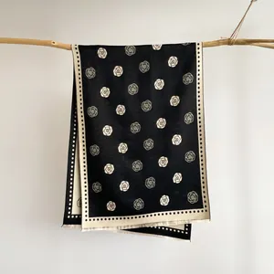 Detail view of premium camellia jacquard scarf featuring elegant black and white floral texture